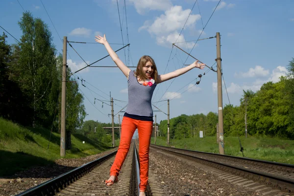 Beautiful girl walks on the rails — Stock Photo, Image