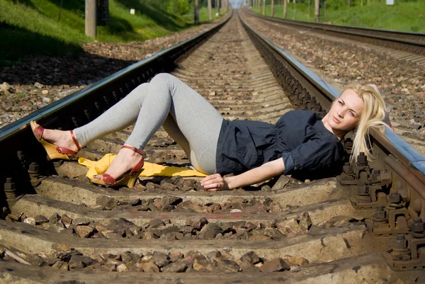 Ragazza bionda sdraiata sulle rotaie — Foto Stock