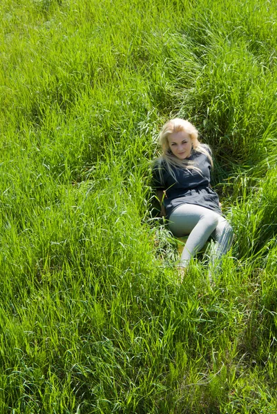 Flicka, blond liggande i gräset — Stockfoto