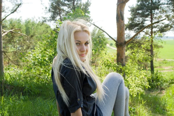 The girl sits in the forest — Stock Photo, Image