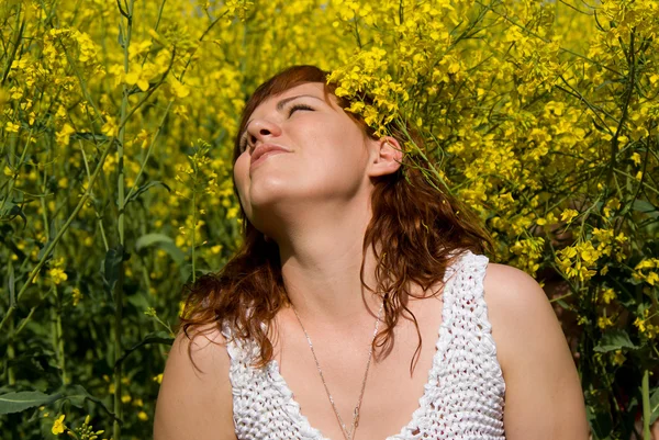 Menina bonita descansar no campo de colza — Fotografia de Stock