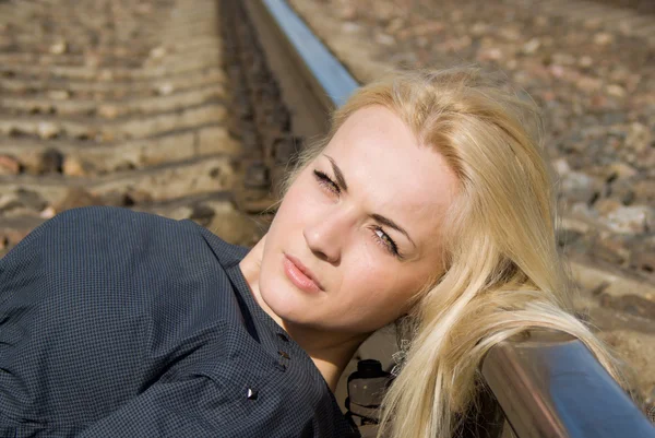 Tjej blondin sätta huvudet på rälsen — Stockfoto