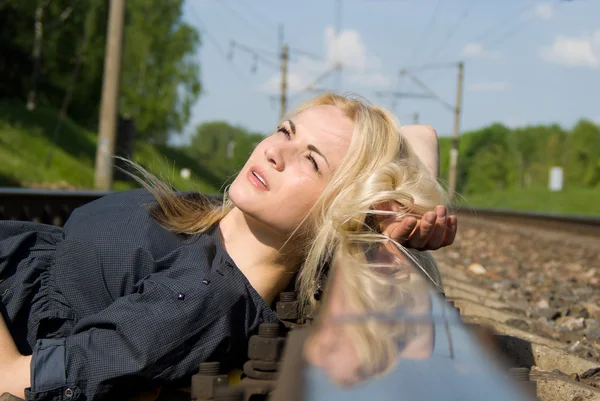 Tjej blondin sätta huvudet på rälsen — Stockfoto