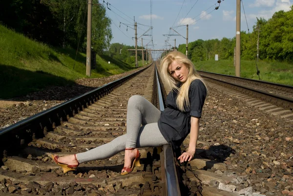 Girl blonde sitting on the rails — Stock Photo, Image