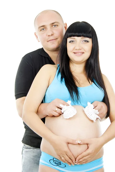 Счастливая беременная пара в детской обуви — стоковое фото