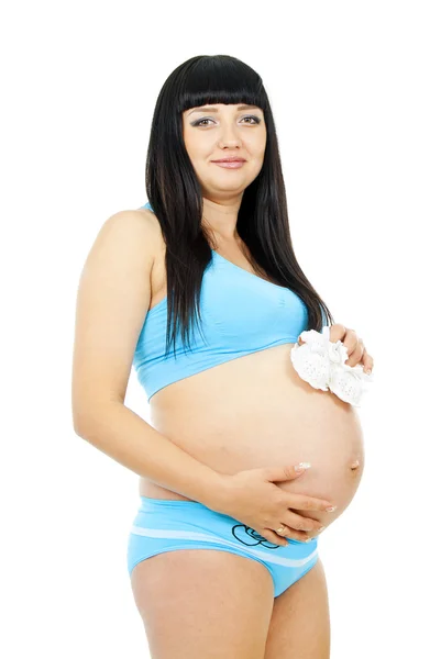 Беременная девушка в детской обуви — стоковое фото