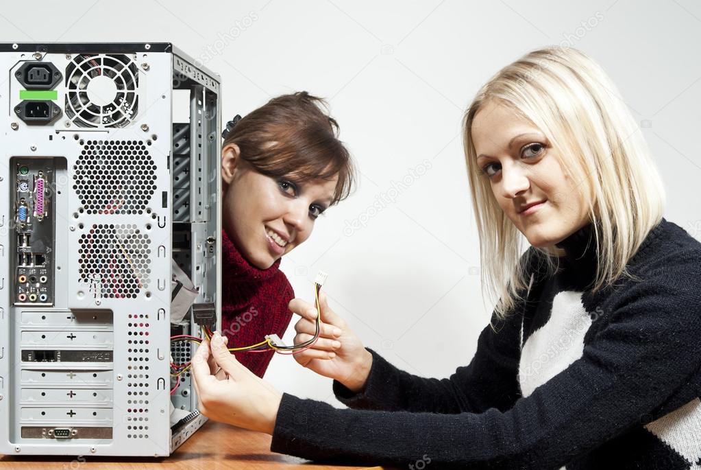 Two girls repairing computer