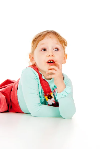 Een beetje meisje poses, leugens — Stockfoto