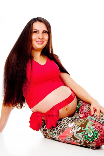 Pregnant girl with a red bow on her stomach — Stock Photo, Image