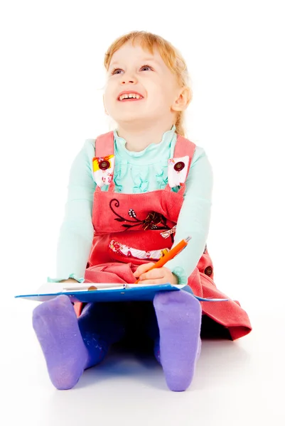 En liten flicka sitter och målar — Stockfoto