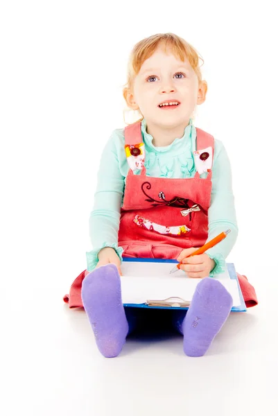 A little girl sits and paints Stock Photo