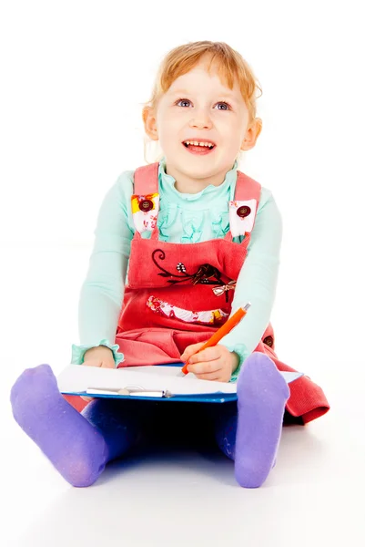 A little girl sits and paints Stock Photo