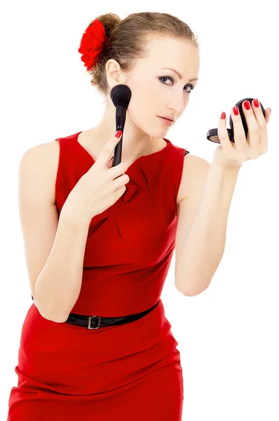Девушка в красном платье, накладывает макияж — стоковое фото