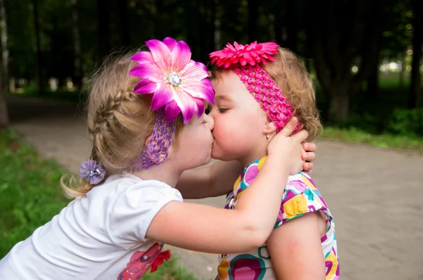 little girl kisses its little sister