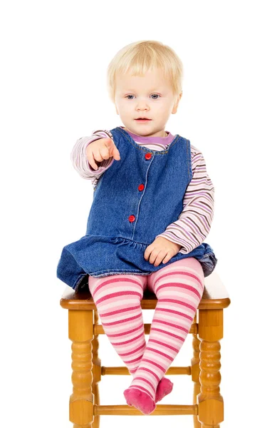 Beautiful little girl sitting on a chair — Stock Photo, Image