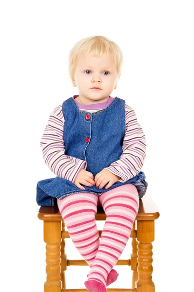 Niña sentada en una silla Imagen de stock