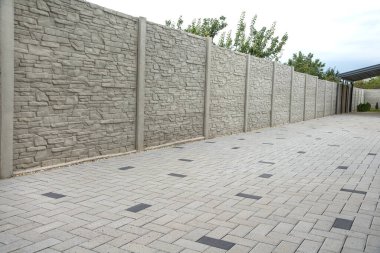 Beton desenli çitler ve kaldırım taşlarını engelliyor.