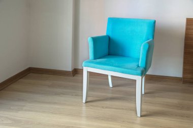 Odada turkuaz koltuk var. Ahşap zemin