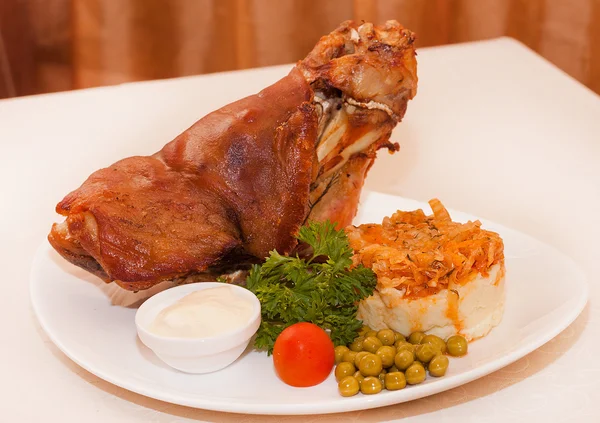 Pork shank with mashed potatoes and peas — Stock Photo, Image