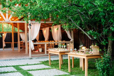 Delicious catering banquet buffet table decorated in rustic style in the garden. Different snacks and sandwiches. Outdoor.