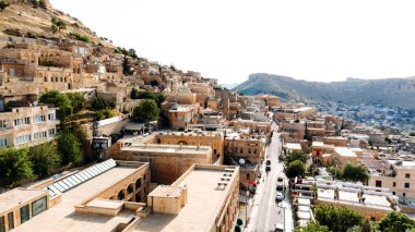 Aerial drone view to the streets of the ancient city Mardin, Mesopotamia, Turkey. Mardin cityscape with roofs and minarets in old town