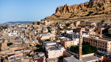 Aerial drone view to the streets of the ancient city Mardin, Mesopotamia, Turkey. Mardin cityscape with roofs and minarets in old town