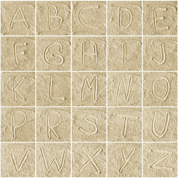 Handwritten alphabet letters on sand — Stock Photo, Image