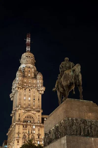 Громадський статуї і хмарочос вночі — стокове фото