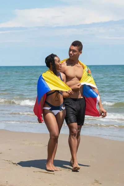 Egy venezuelai zászlóba csomagolt pár, miközben együtt sétáltak a parton.. — Stock Fotó
