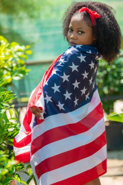 Amerikan bayrağına sarılmış Afrikalı Amerikalı kadın.