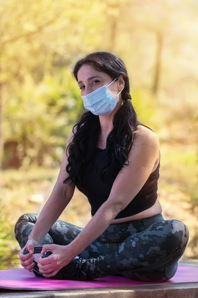 Woman with face mask in a yoga pose