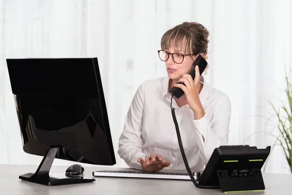 Beyaz Gözlüklü Beyaz Gömlekli Bilgisayar Kullanan Telefonda Konuşan Beyaz Bir - Stok İmaj