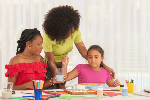 Zwei Lehrerinnen Helfen Dem Mädchen Kunstunterricht Beim Malen Multiethnische Menschen lizenzfreie Stockbilder