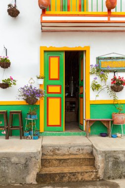 Beautiful facades of the houses Salento city in Colombia. Colorful door of traditional houses, green, orange, yellow