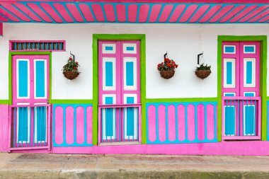 Beautiful facades of the houses Salento city in Colombia. Colorful door of traditional houses, green, pink, blue