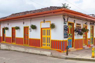 Salento, Quindio, Colombia - February 2022. The beautiful doors and facades of the houses. Colorful door of traditional houses, green, orange, yellow