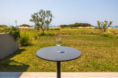 Bahçe masasındaki deniz manzaralı su camının güzel manzarası. Yunanistan. 