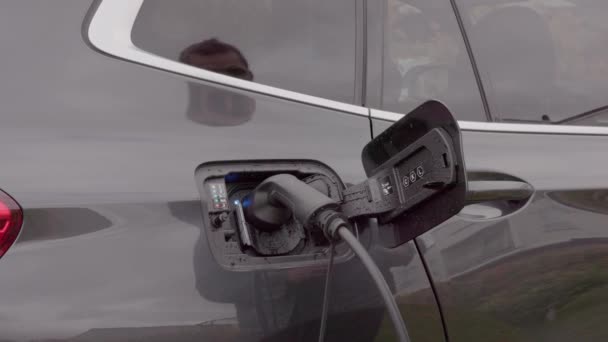 電気自動車の充電ステーションに充電ケーブルを差し込む男のビューを閉じます スウェーデン — ストック動画