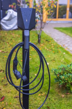 Şehrin ön bahçesindeki elektrikli araba şarj istasyonunu kapatın. İsveç. 