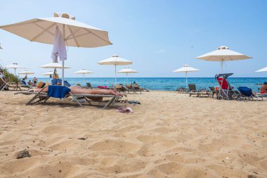Güneşli yaz gününde kumsaldaki turistlerin güzel manzarası. Yunanistan. Nea Potidaea. 03.09.2021.