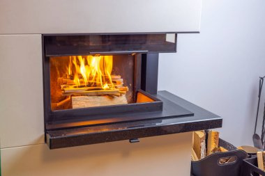 Oturma odasındaki modern şöminenin güzel manzarası. Şöminede yanan odun manzarası. Güzel arka planlar. İsveç.