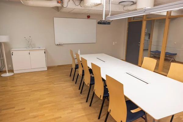 Beautiful view of modern conference meeting room. White office table, board and chairs. Business concept. Modern office style. Sweden