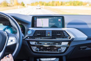 Elektrikli araba BMW iX3 'ün direksiyonundaki kadın ellerinin yakın görüntüsü. İsveç. Uppsala. 10.24.2021.