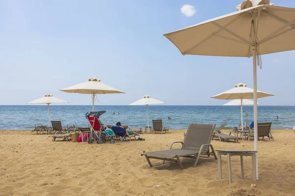 Güneşli yaz gününde kumsaldaki turistlerin güzel manzarası. Yunanistan. Nea Potidaea. 03.09.2021.