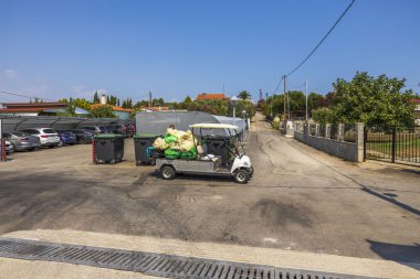 Otelin arka bahçesinde kirli çamaşırları olan elektrikli araba manzarası. Yunanistan. Nea Potidaea. 07.20.2021.