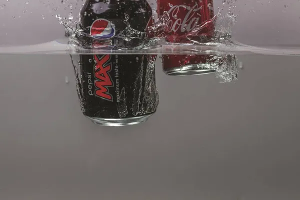 Vista Perto Duas Latas Caindo Água Coca Cola Pepsi Cola — Fotografia de Stock