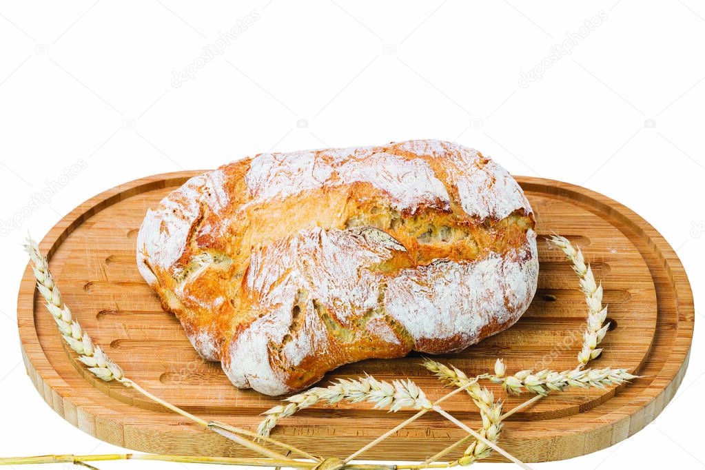 Close up  view of whole grain loaf white bread and wheat ears on a cutting board isolated on white background. 