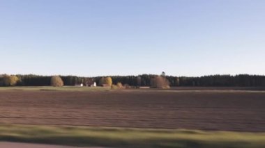 Güzel bir sonbahar günü ve arabanın manzarası. Tarlaları, orman ağaçları ve beyaz bulutlu mavi gökyüzü olan muhteşem bir manzara. İsveç.