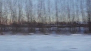 Güzel bir kış günü ve arabadan manzara. Nehir, tarlalar, orman ağaçları ve mavi gökyüzüyle muhteşem bir manzara. İsveç.