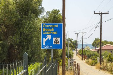 Köyün arka planındaki plaj kampı tabelasının güzel manzarası. Yunanistan. 
